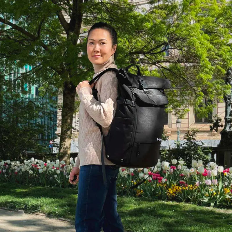 Junge Frau mit Rucksack dreht sich zur Kamera und lächelt.