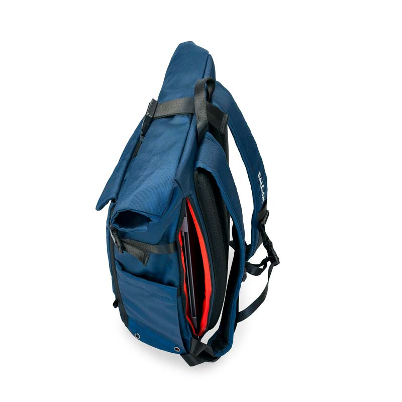 Blauer Rolltoprucksack der Marke BALÔ-ON, linke Seitenansicht, mit seitlicher Tasche für Wasserflasche und Schnellzugriff auf das Laptopfach; Innenstoff ist rot.