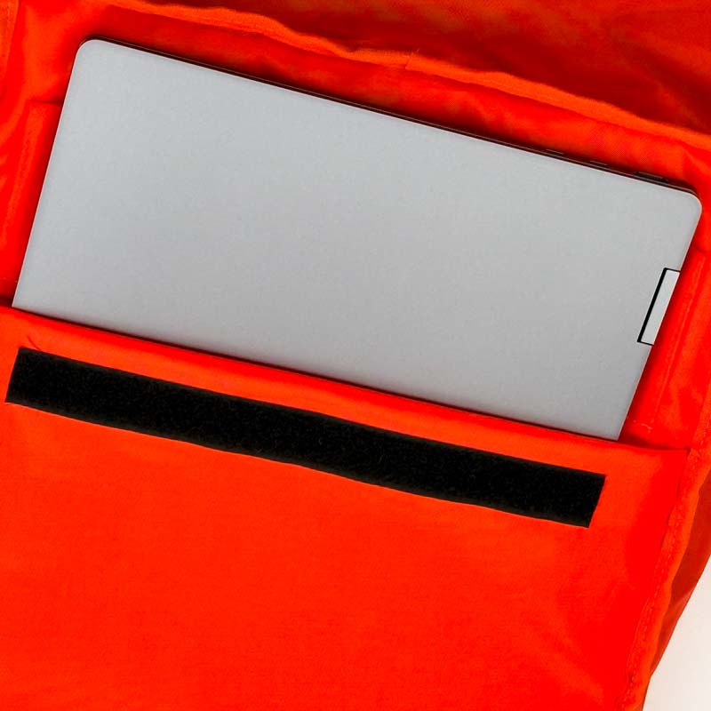 Gepolstertes Laptopfach mit Klettverschluss; der Innenstoff ist rot.