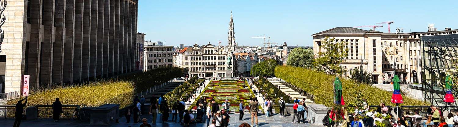 Mont des Arts in Brüssel bei sonnigem Wetter, zahlreiche Touristen spazieren und genießen die Aussicht.